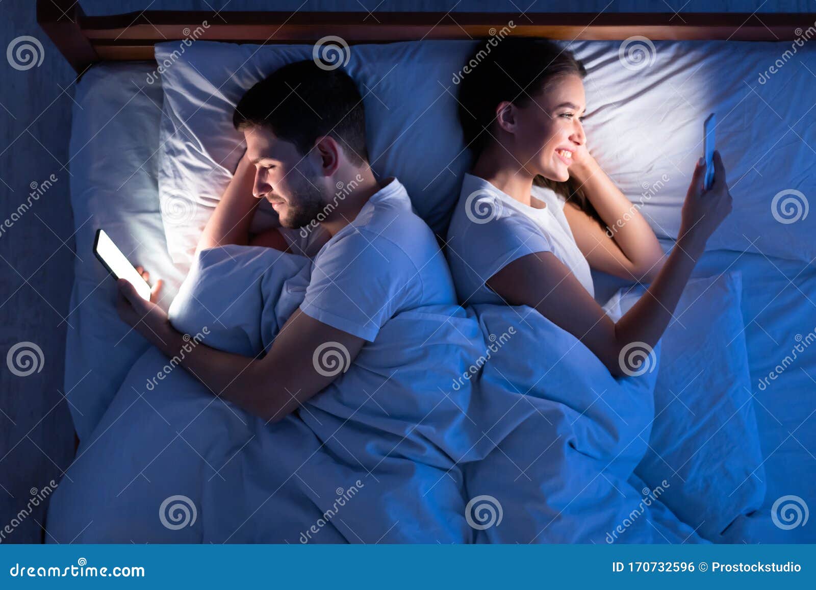 Couple Texting On Phones Lying Back-To-Back In Bed, Above View Stock Google Couple Texting In Bed R 34
