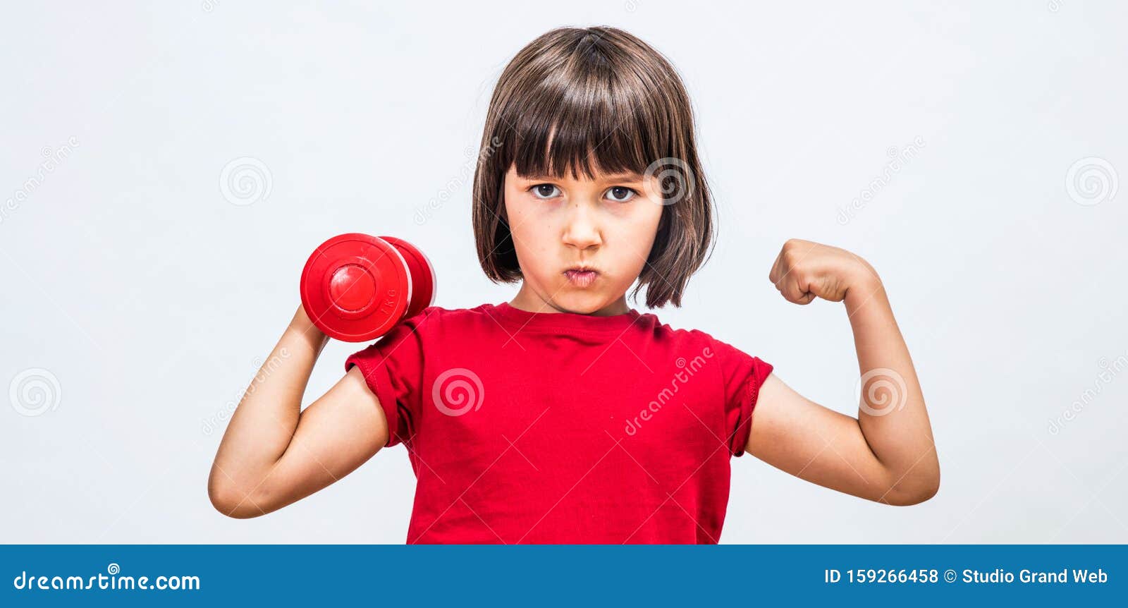 cheeky child pouting, raising hands with dumbbell and strong fist