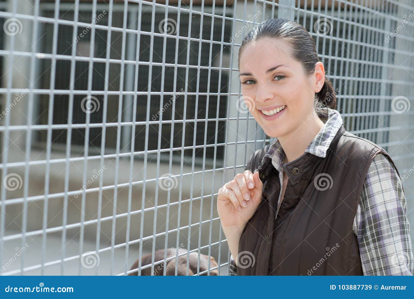 cheerful apprentice vetenary posing at kennel