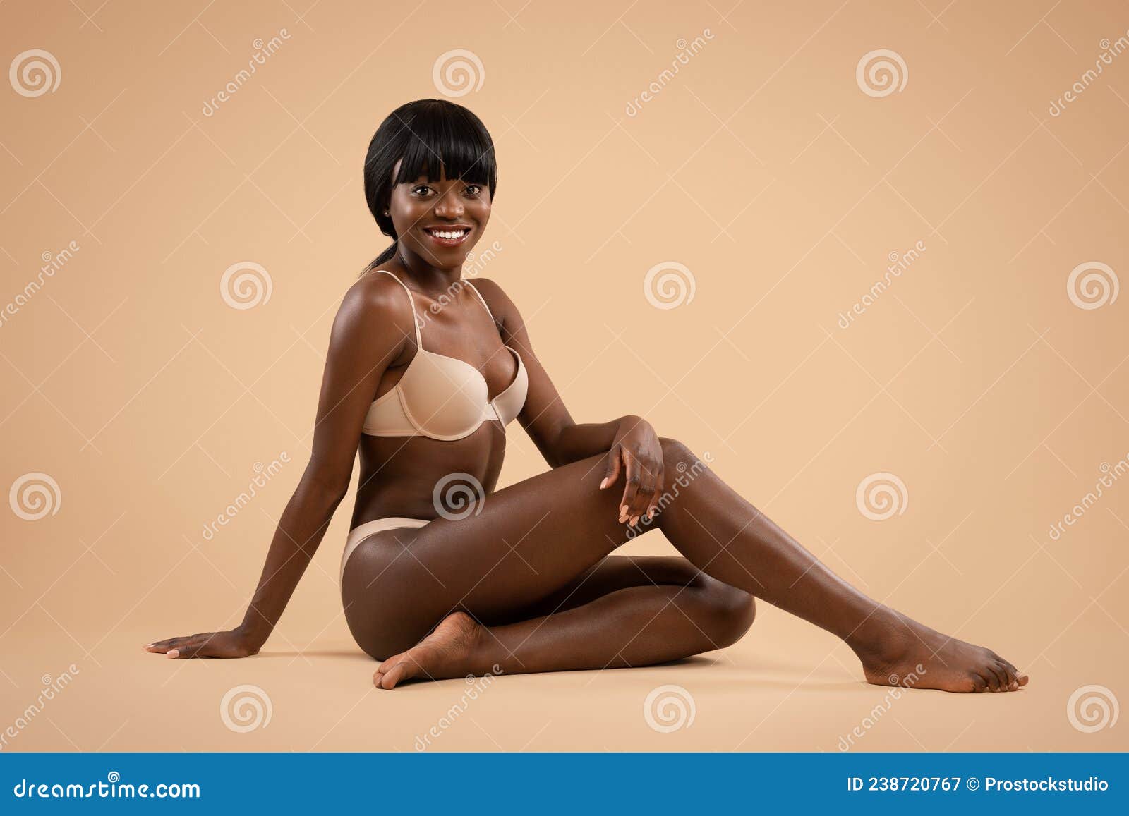 Cheerful Attractive Black Lady Posing in Underwear on Beige Stock