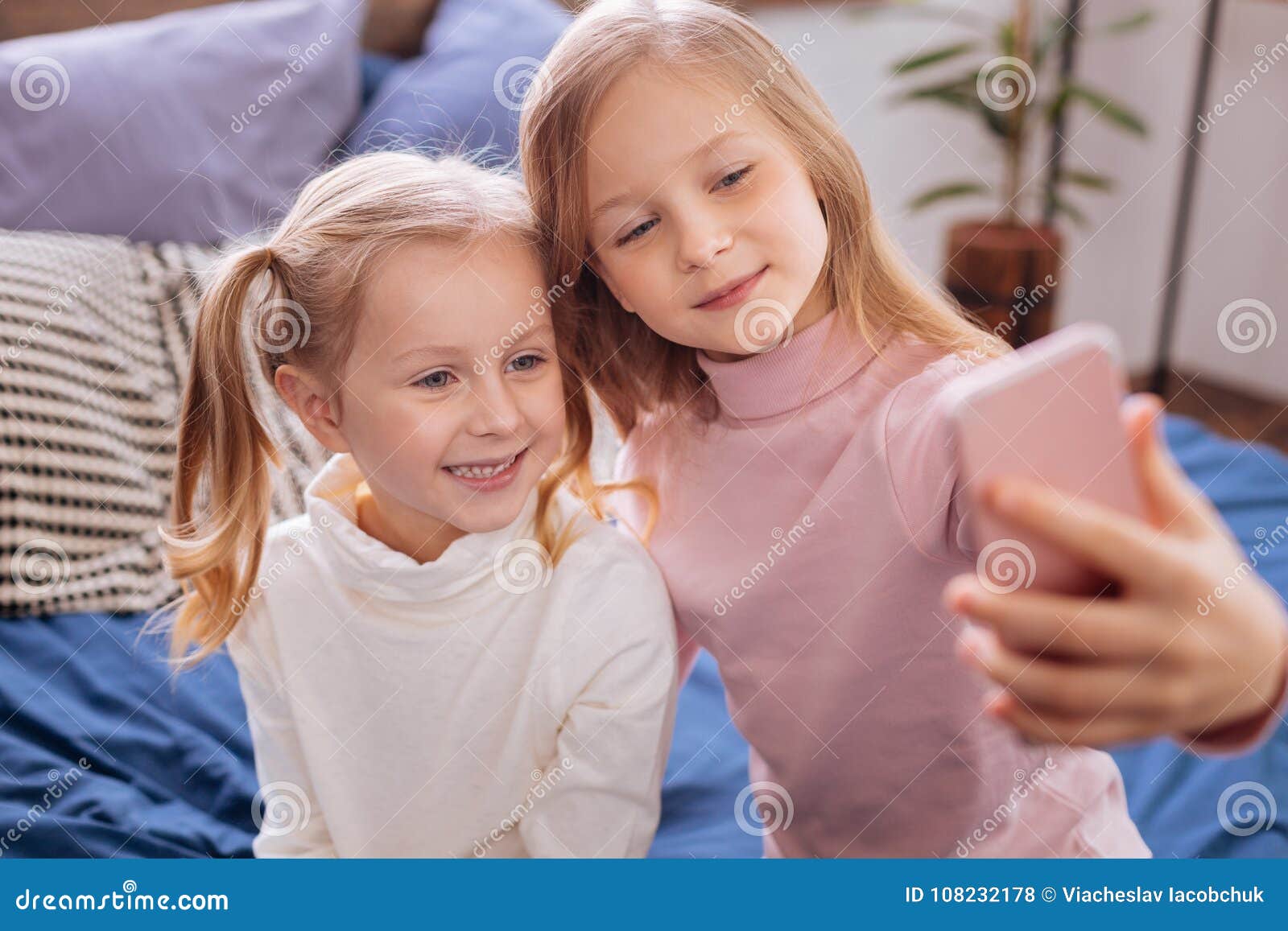 Cheerful Blond Sisters Taking Pictures on Their Phone Stock Photo ...