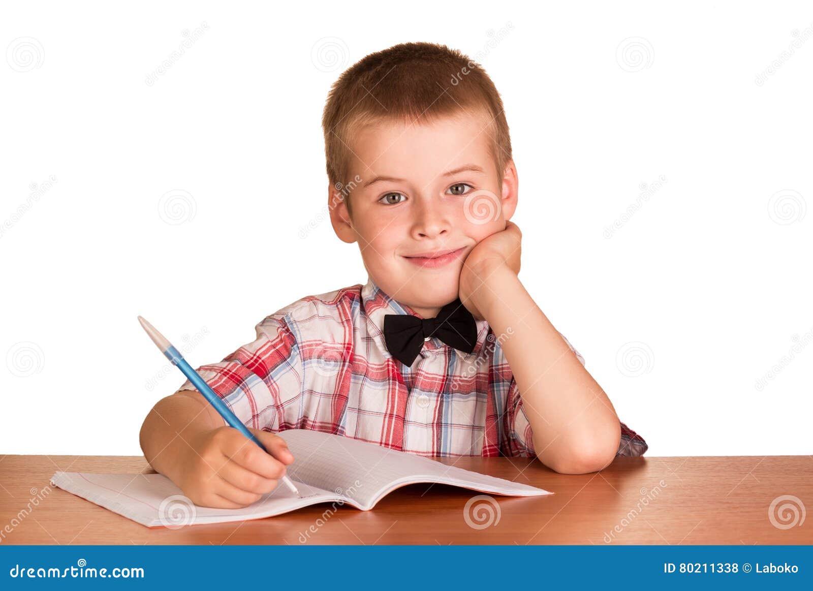 Cheerful Boy With Pen Sitting At Desk Over Exercise Book Stock