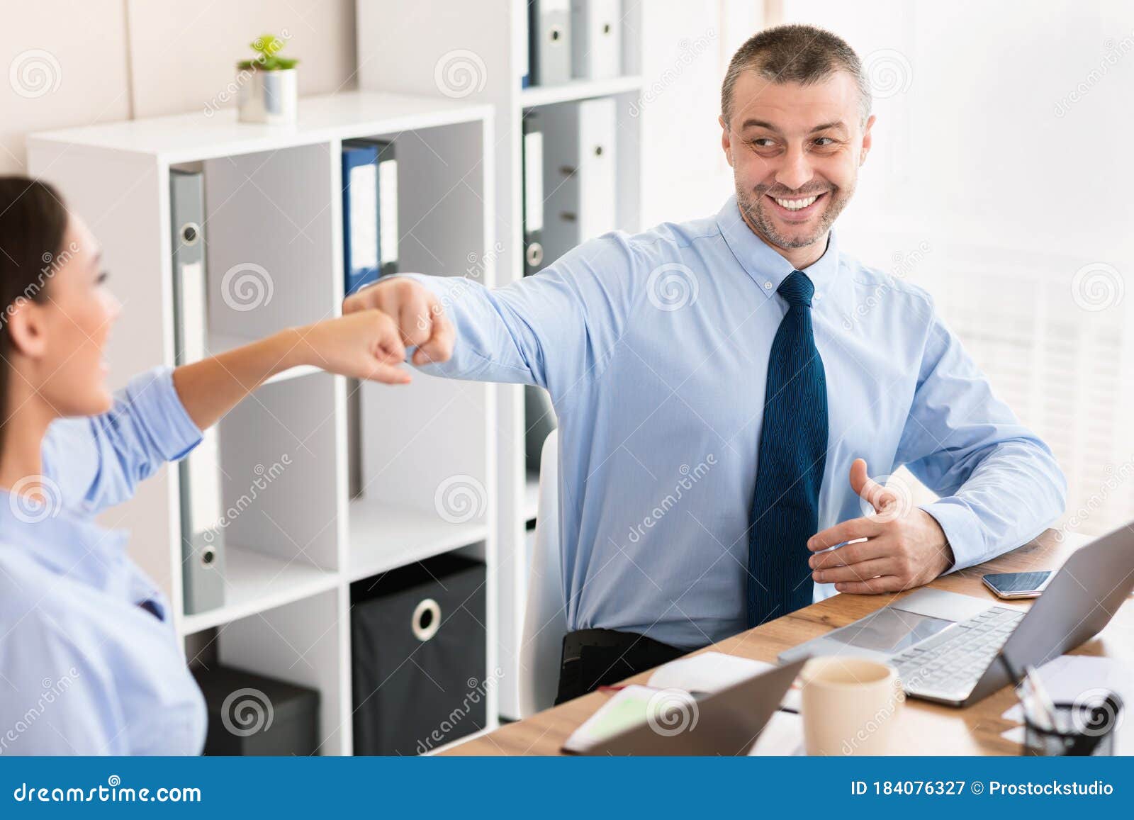 Cheerful Business Coworkers Bumping Fists Celebrating Success Sitting In Office Stock Image 