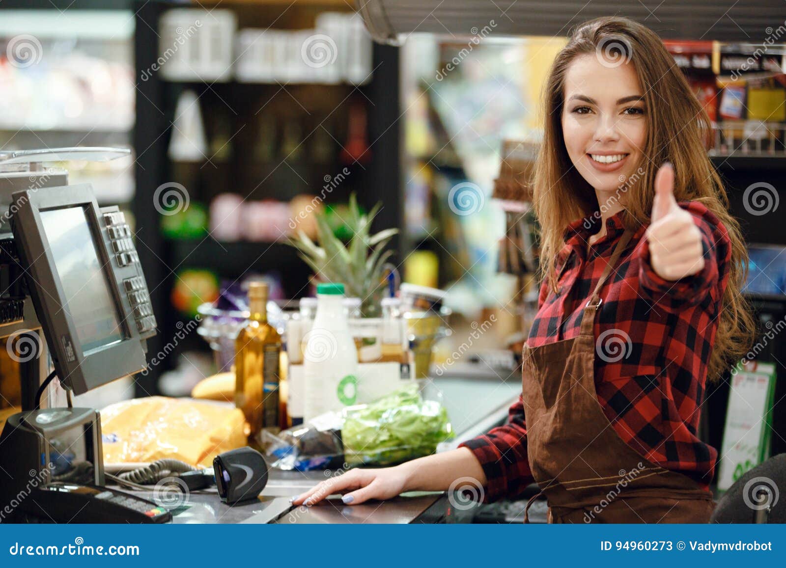 cheerful cashier woman on workspace showing thumbs up.