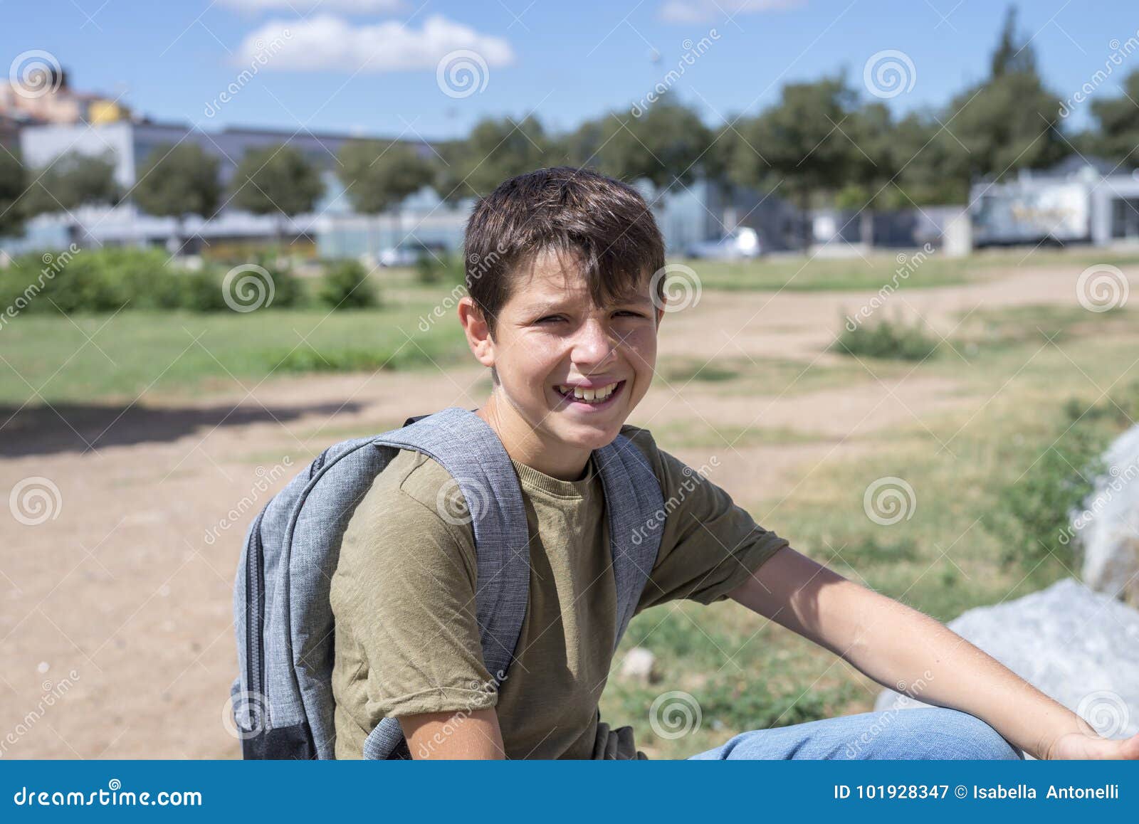 Cheerful Child Carrying His Backpack Standing in Front of the Sc Stock