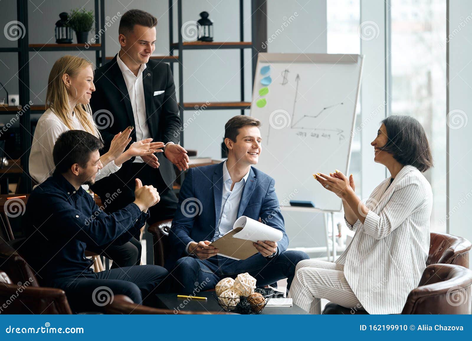 cheerful company of young business poeple. applauding, havin fun in the meeting