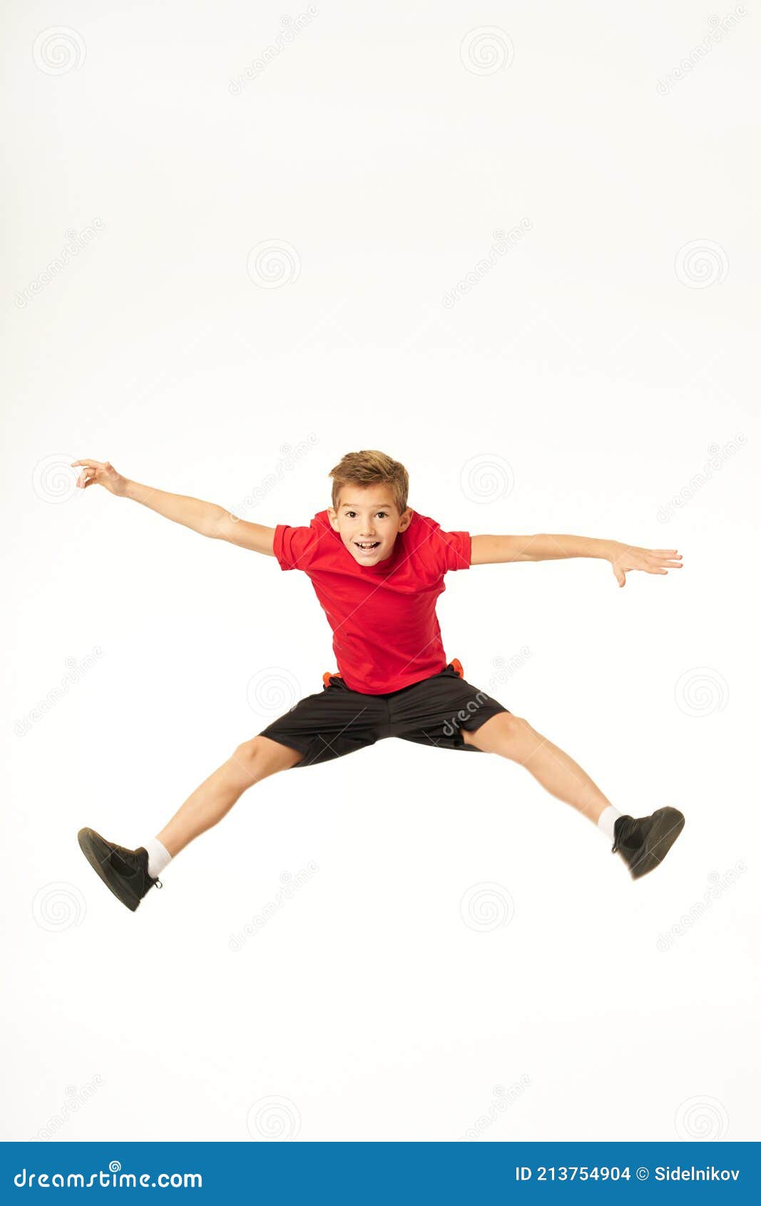 Cheerful Cute Boy in Sportswear Jumping in Studio Stock Photo