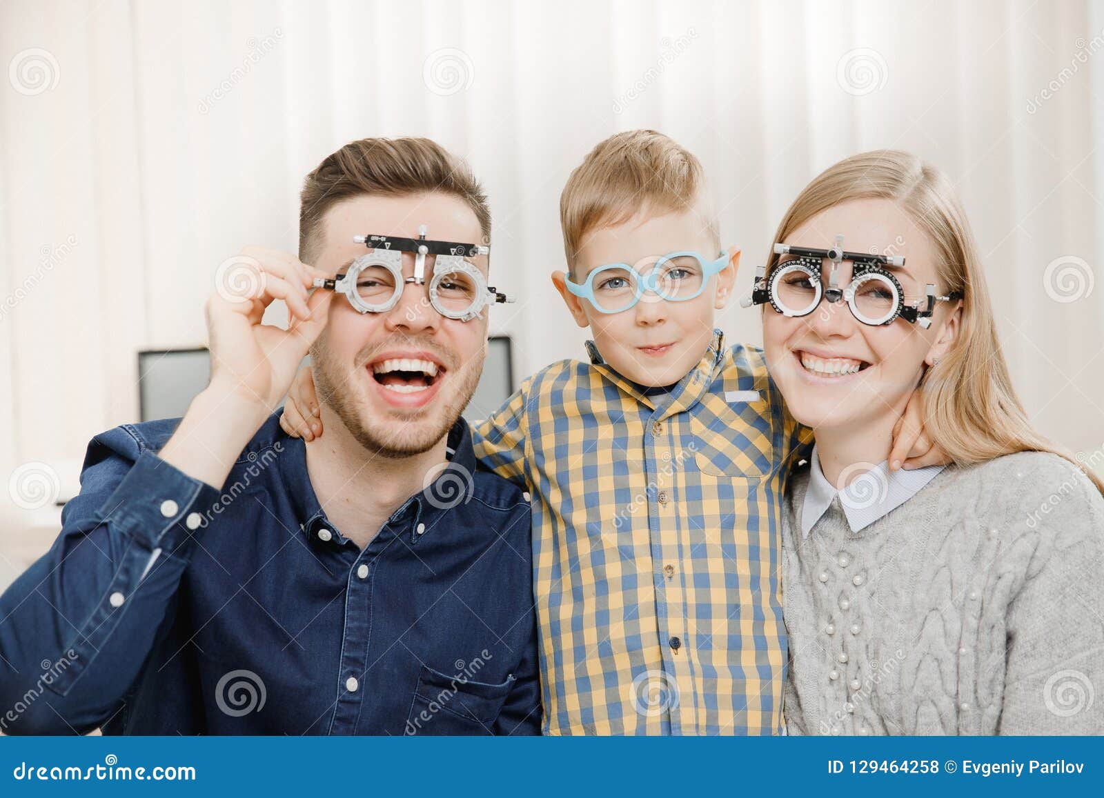cheerful family with small child reception doctor ophthalmologist using glasses