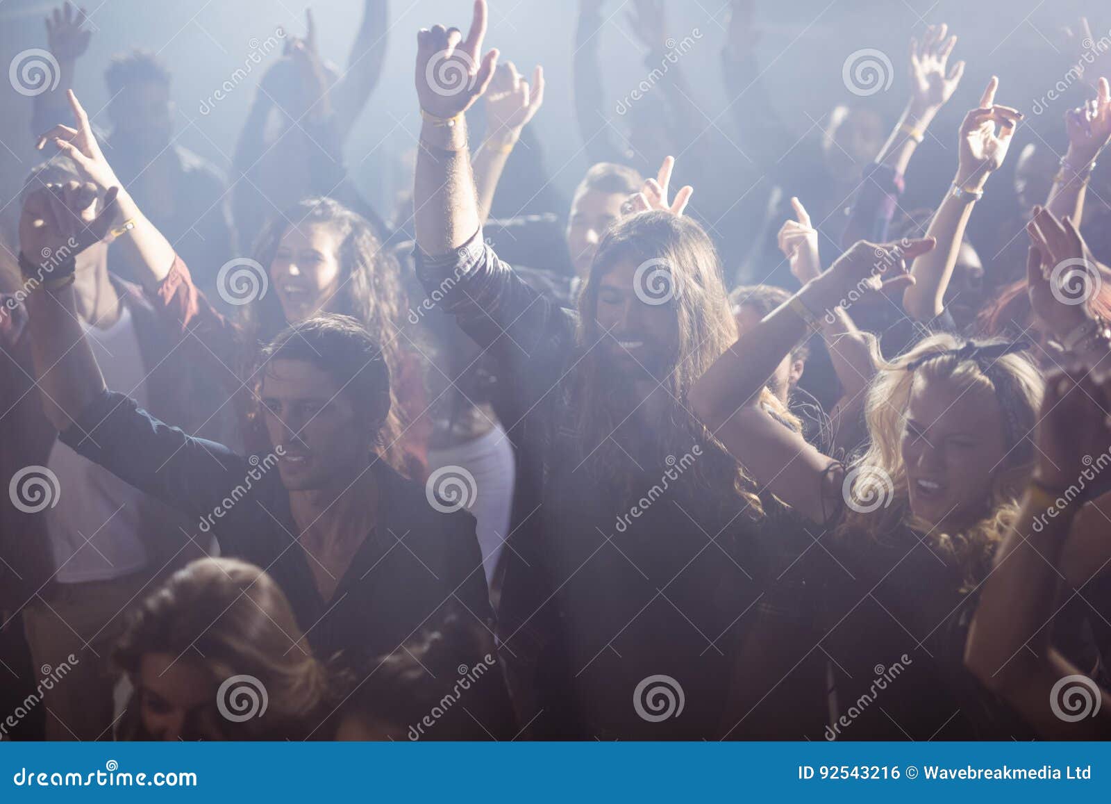 cheerful fans dancing at nightclub during music festival