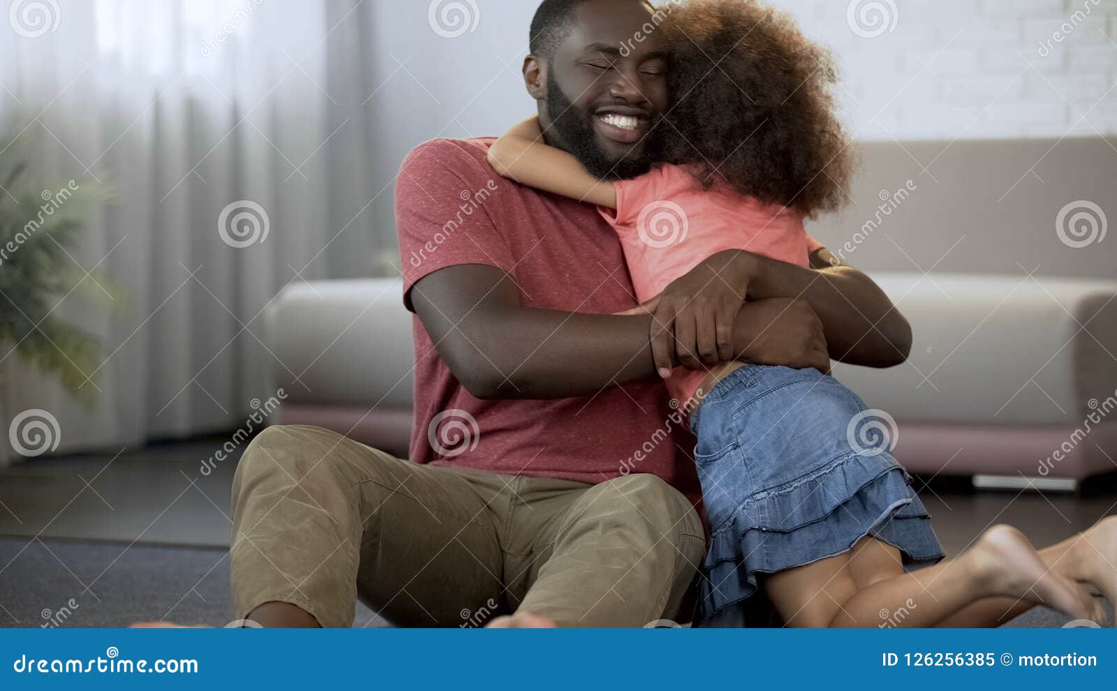 cheerful father hugs cherished daughter, excellent relationship in family