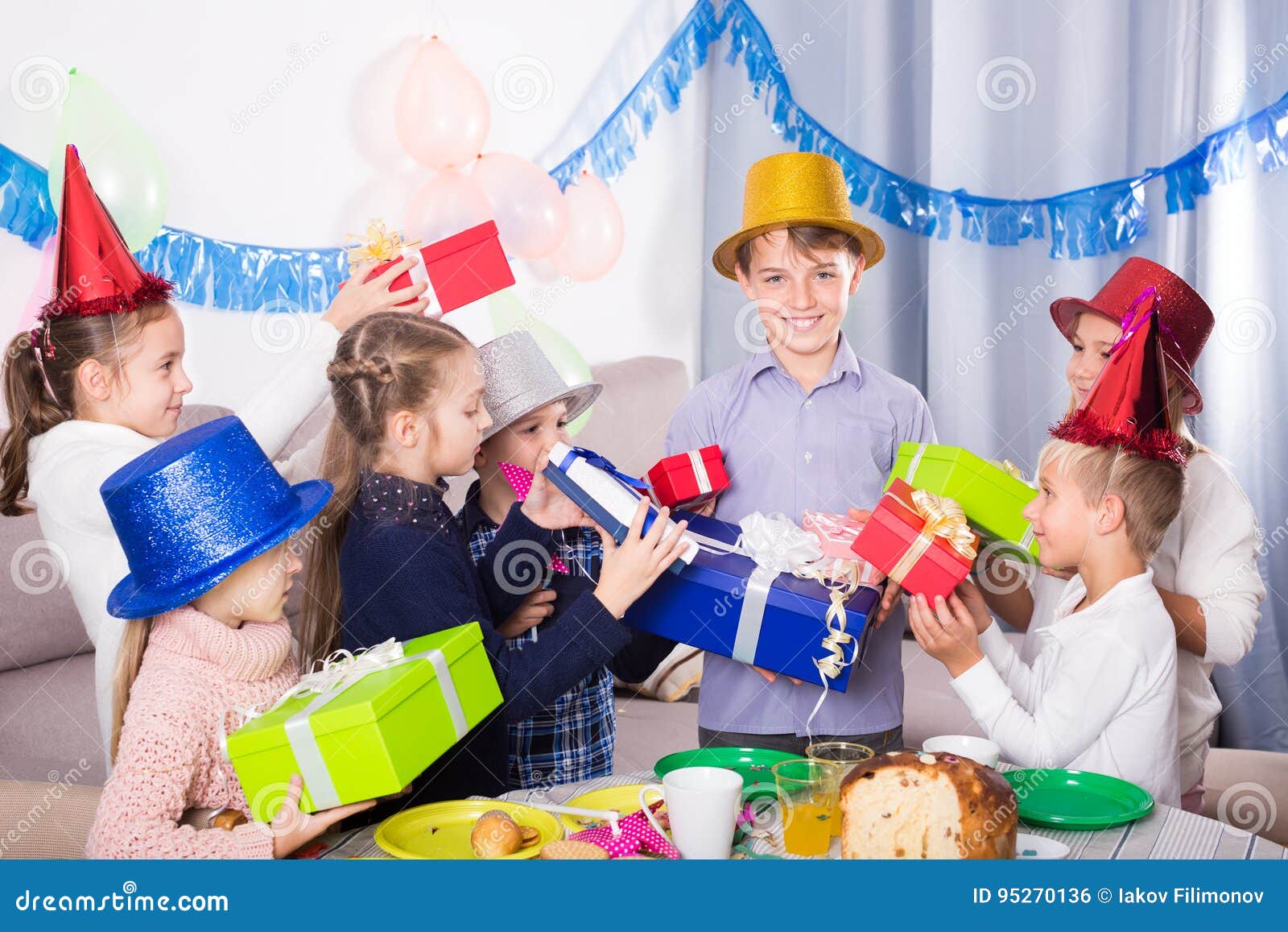 Cheerful Friends Handing Gifts To Birthday Boy Stock Photo - Image of ...