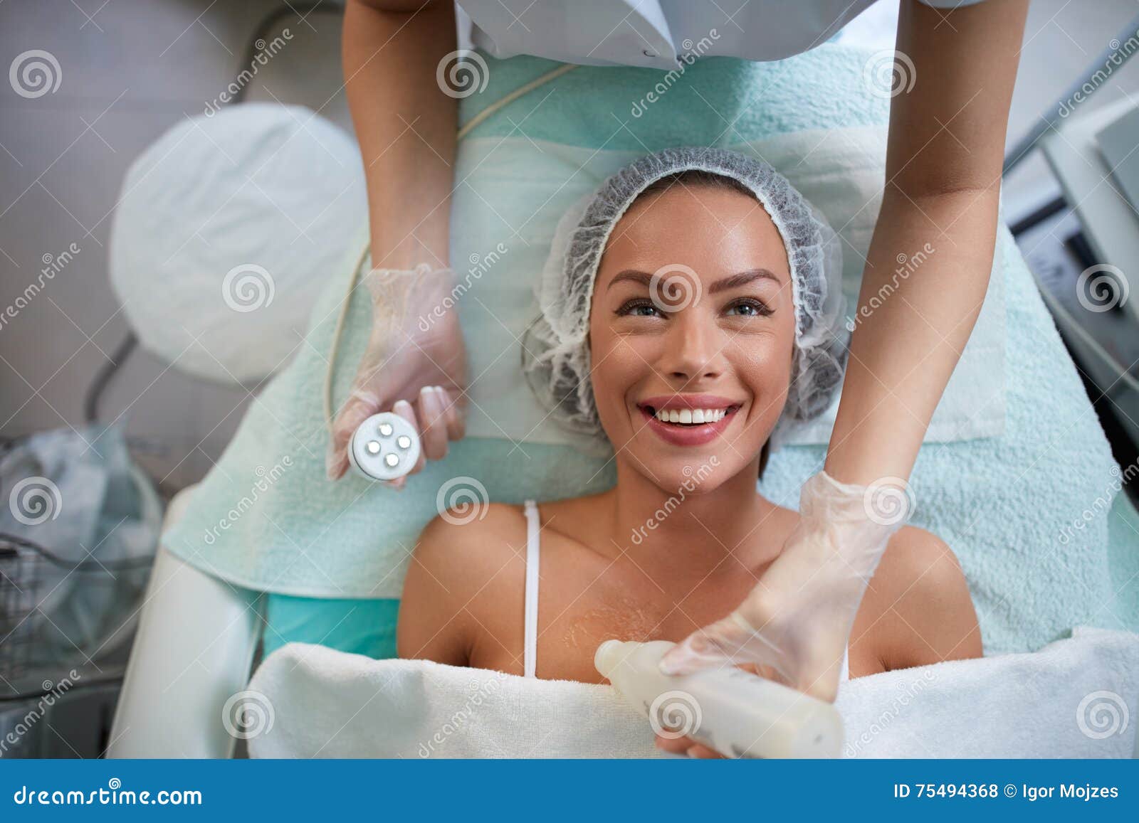 cheerful girl is receiving facial treatment by beautician