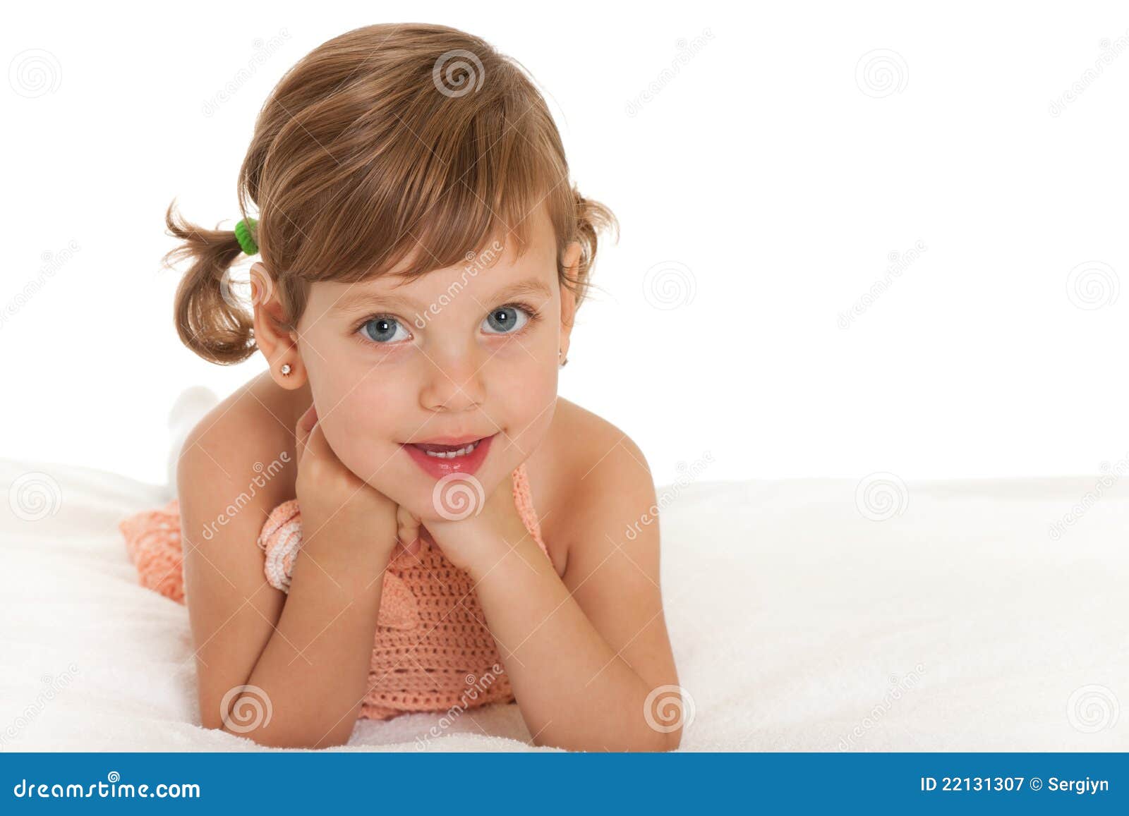 cheerful little girl on the bedspread