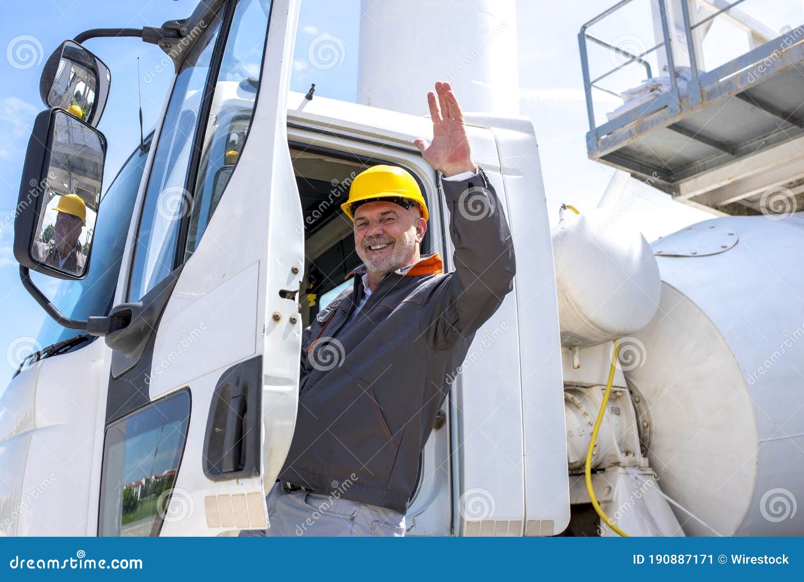 Cheerful Male Construction Worker Waving from a Truck Under the
