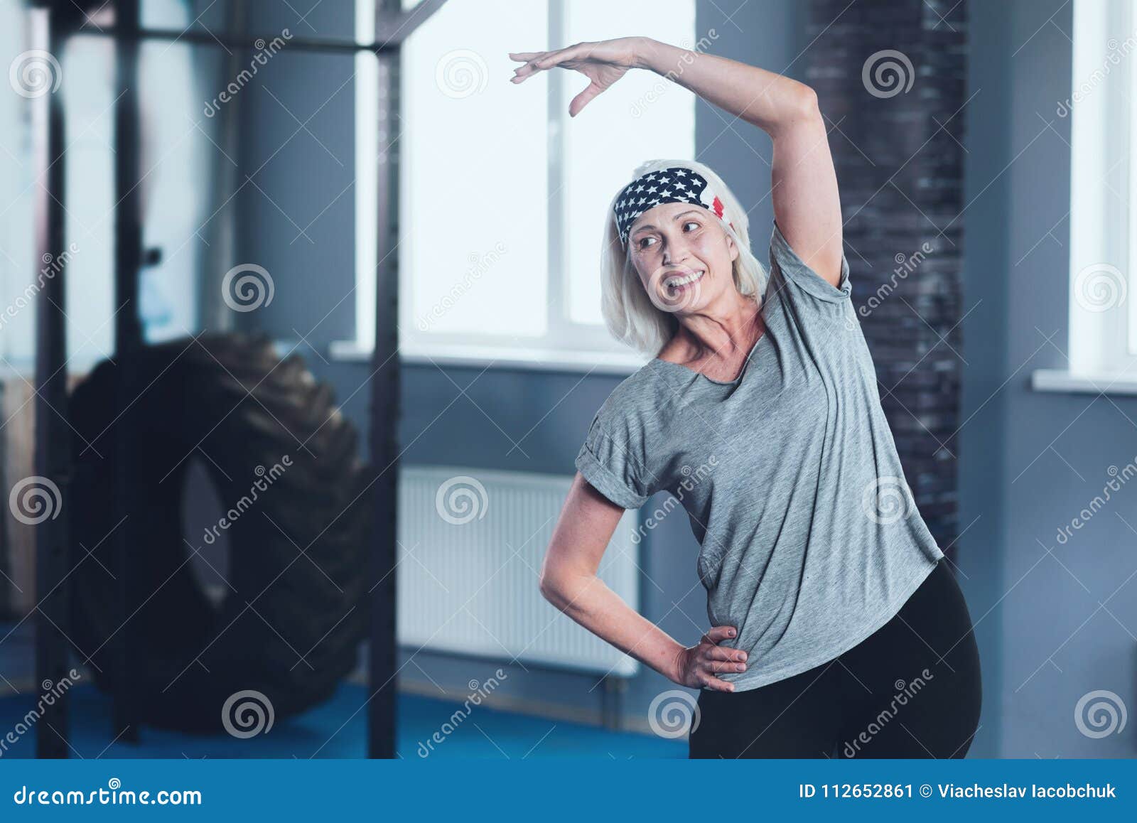 Cheerful Mature Lady Stretching During Training Session Stock Image
