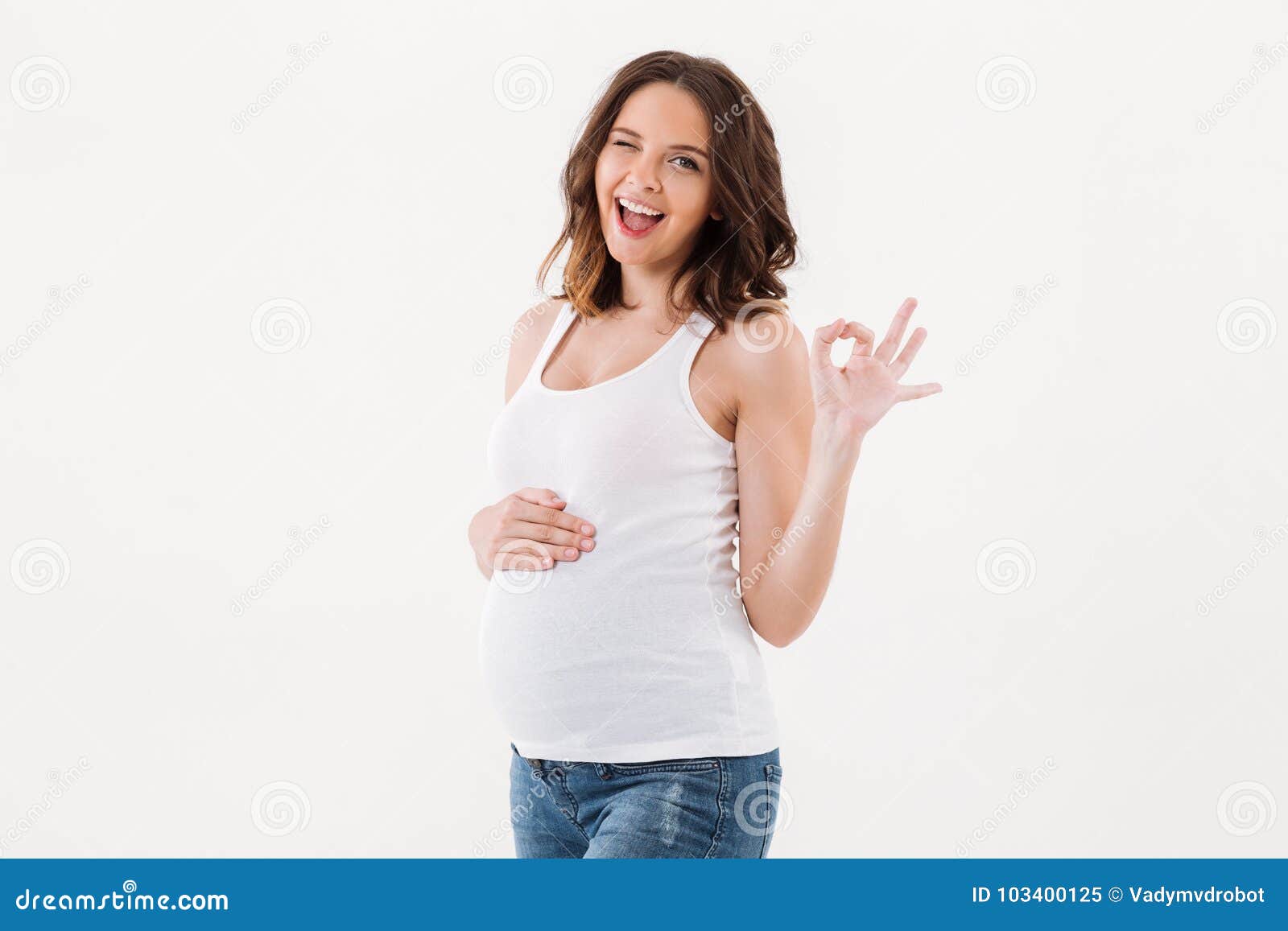 cheerful pregnant woman showing okay gesture.