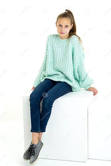 Cheerful Teen Girl Sitting on White Cube in Studio Stock Image - Image ...
