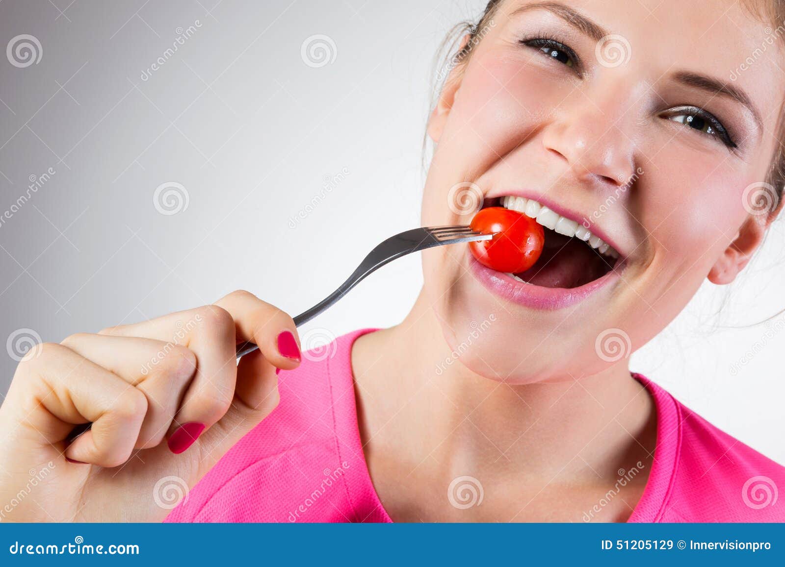 cheerful-woman-eating-cherry-tomato-isolated-51205129.jpg