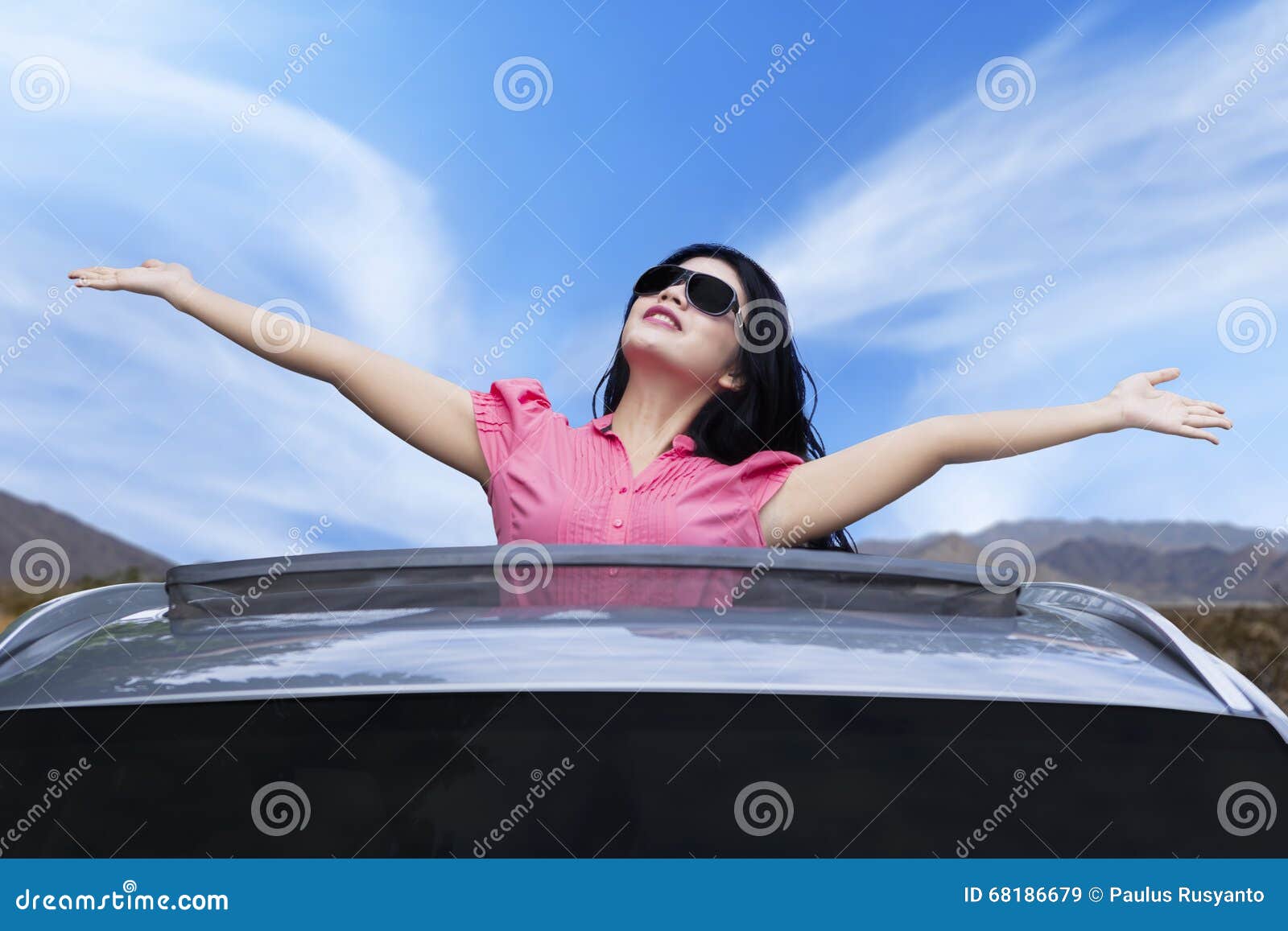 cheerful woman standing on the sunroof