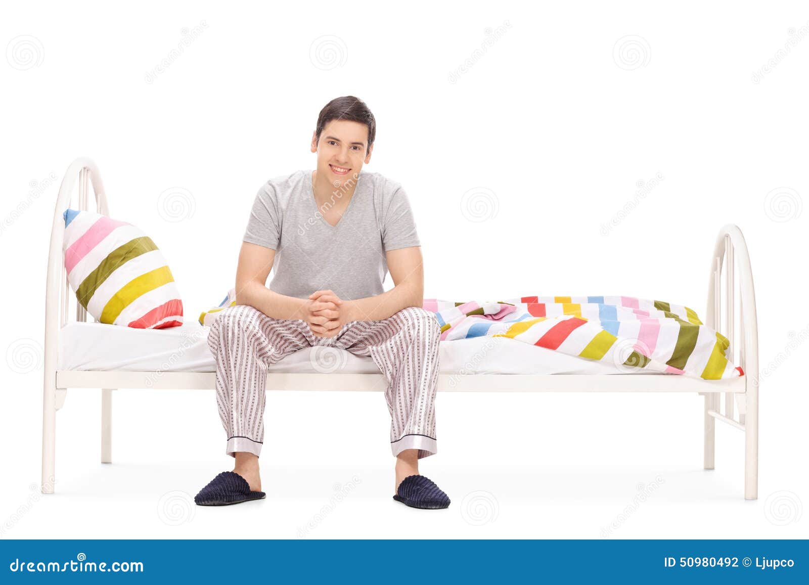 Cheerful Young Guy Sitting on a Bed Stock Photo Image of looking