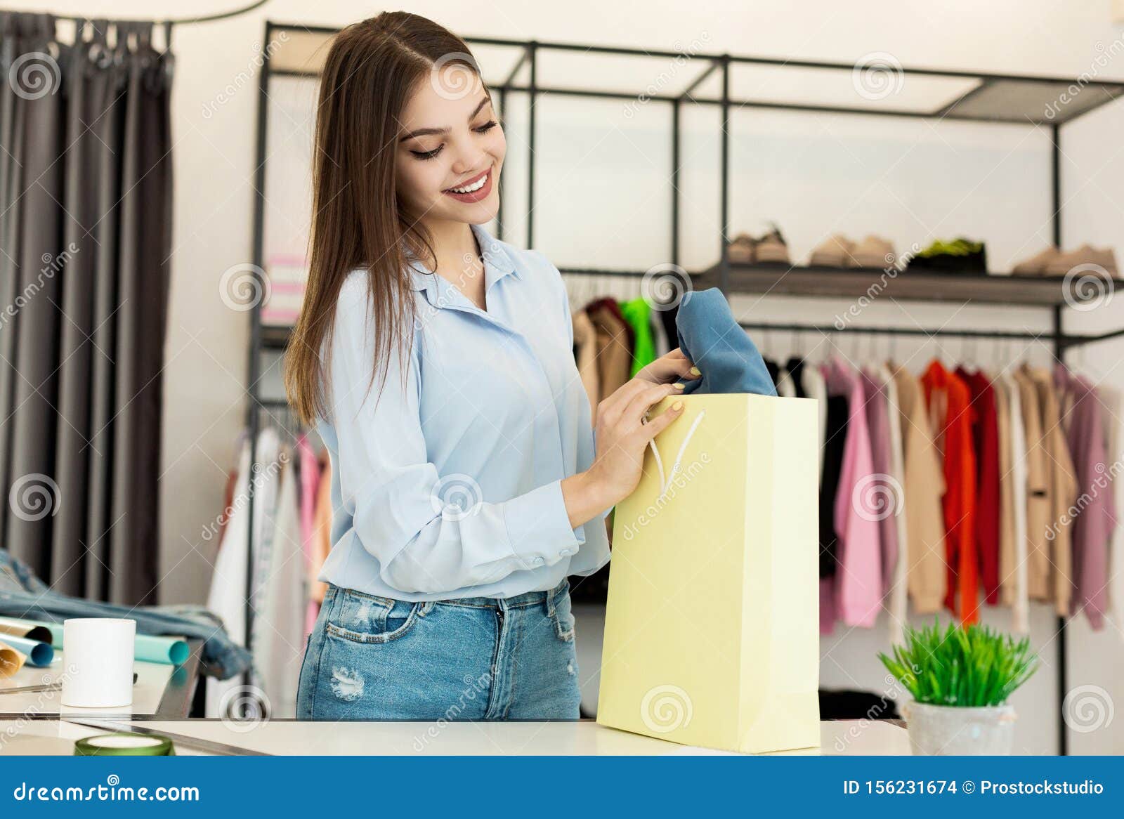 Cheerful Young Woman Buying Clothes in Fashionable Design Studio Stock ...