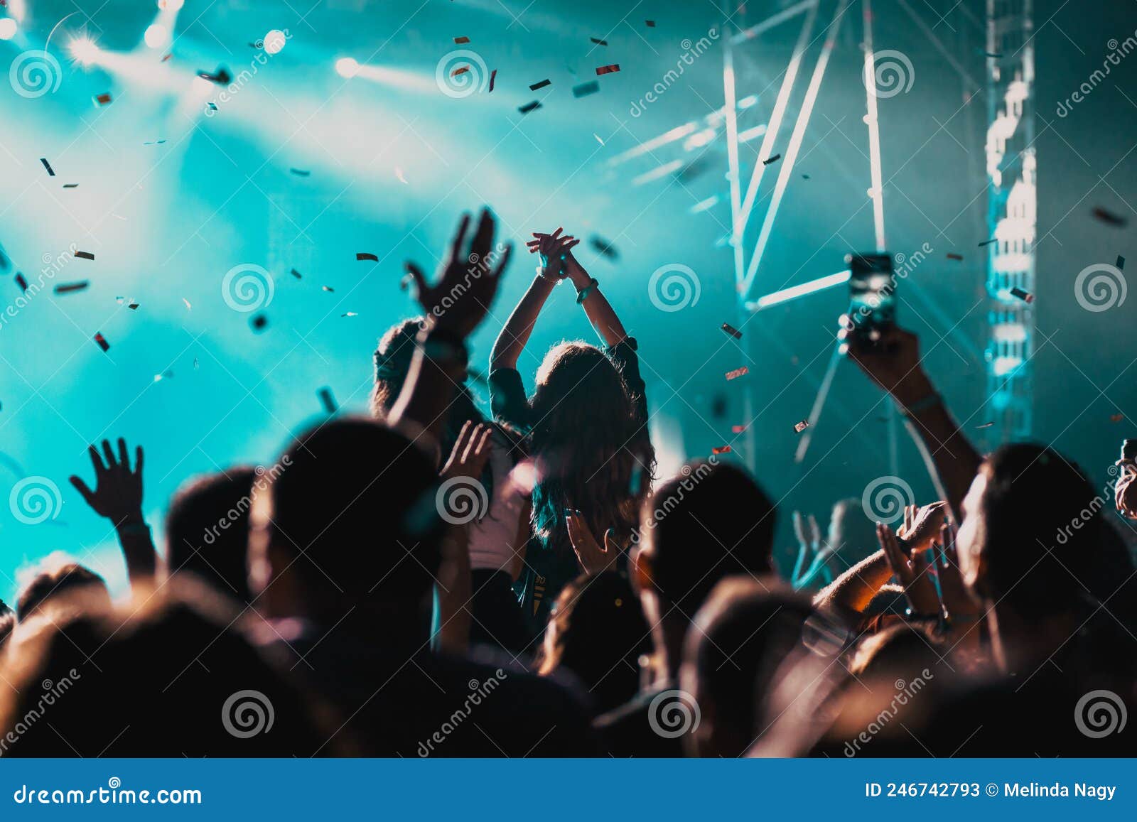 Cheering Crowd with Raised Hands and Falling Confetti at Concert ...