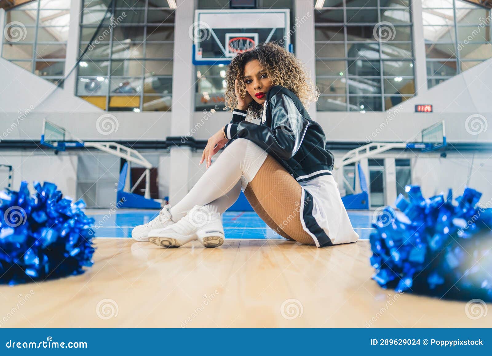 Cheerleader Woman with Afro Hair Sitting on a Basketball Court Floor with Pom  Poms Stock Photo - Image of cheerleader, pose: 289629024