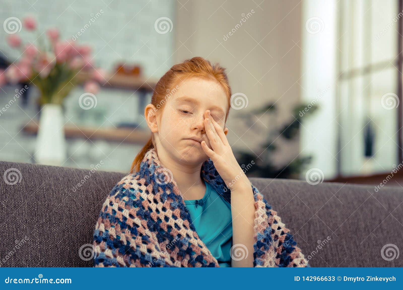 cheerless pale young girl rubbing her face
