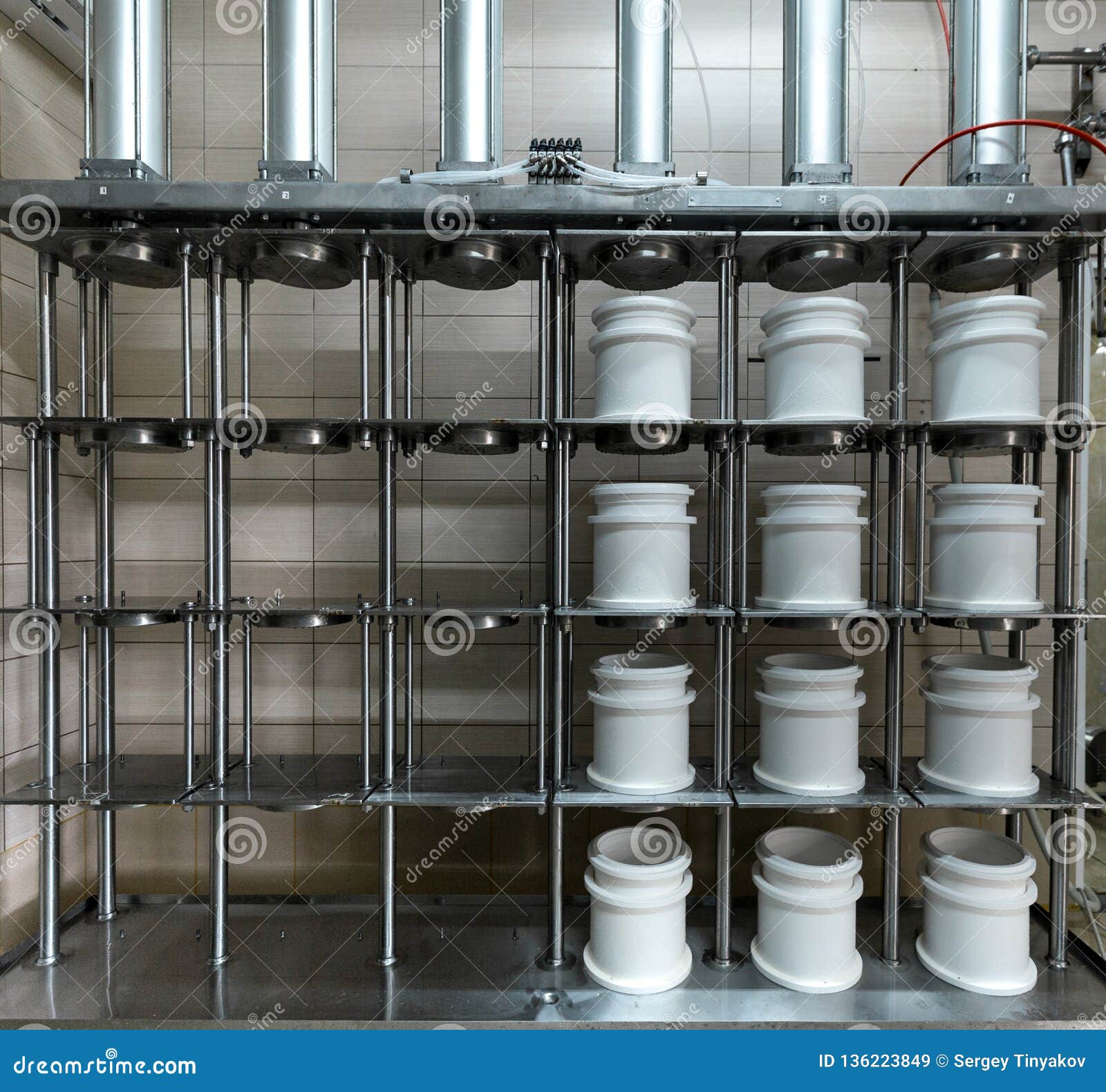 cheese making machine in modern dairy factory. press machine for spinning whey and shaping cheese
