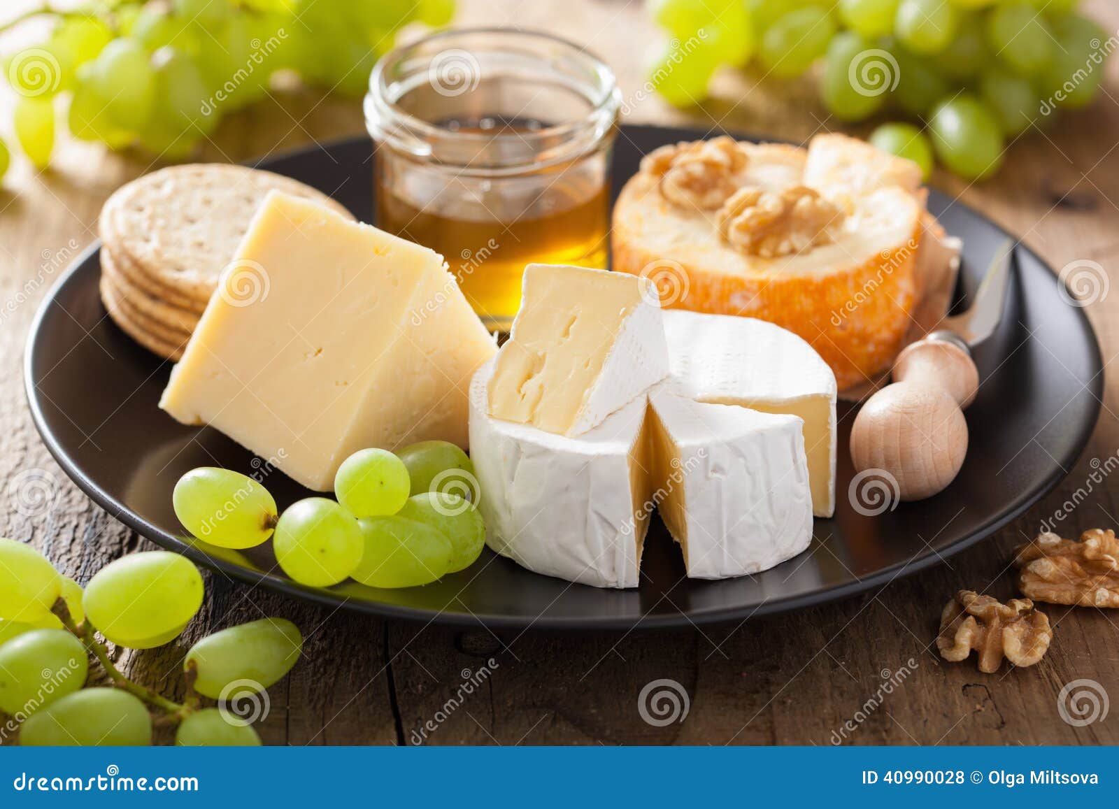 Cheese Plate with Camembert, Cheddar, Grapes and Honey Stock Photo