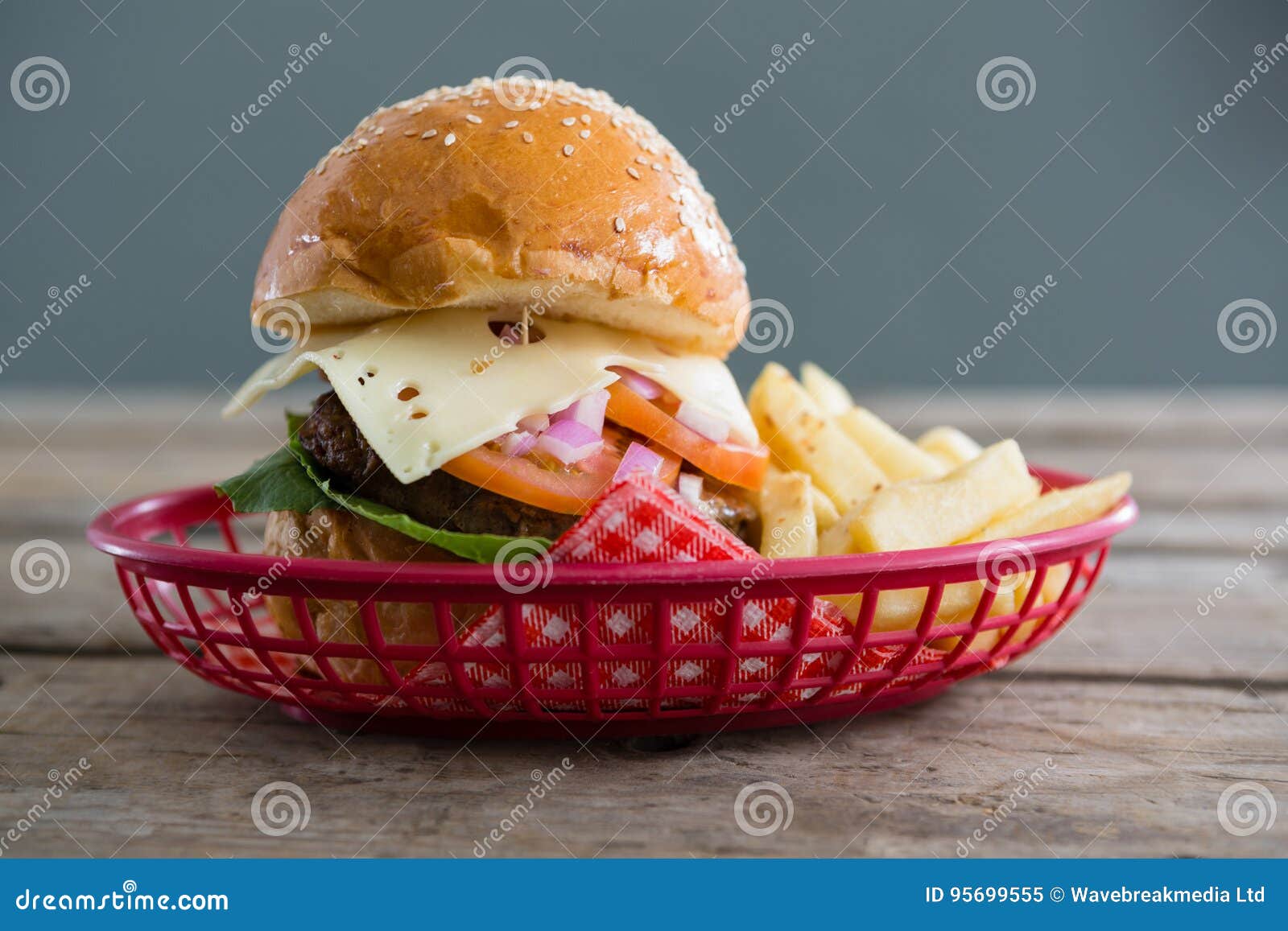 Cheeseburger And French Fries In Basket Against Wall Stock Image