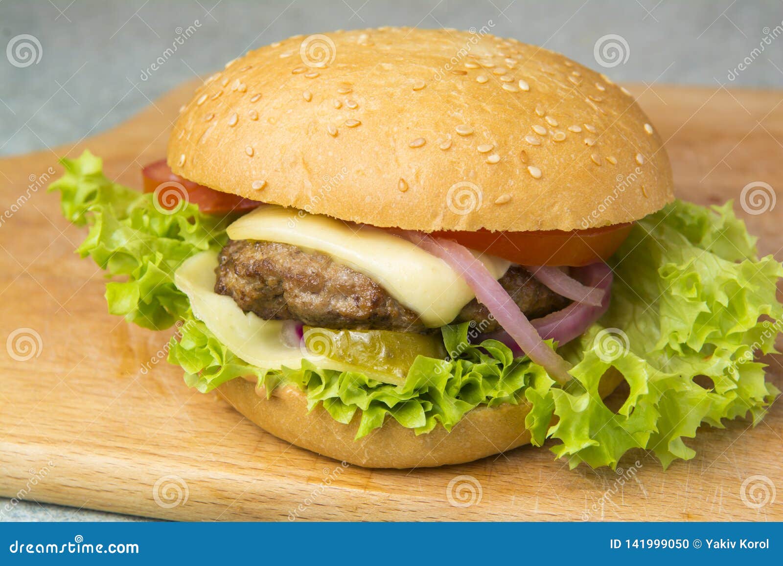Cheeseburger with Lettuce, Tomato, and Onion on a Brioche Bun Stock