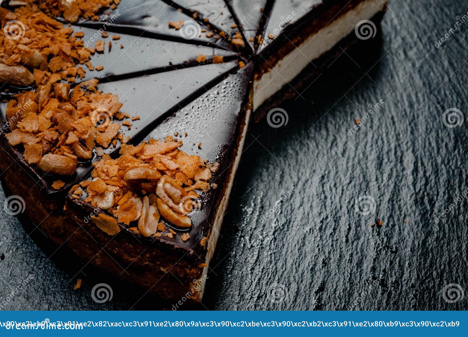 Cheesecake na marmurowym talerzu. Na zmroku - błękita marmuru talerz jest cheesecake pokrojonymi snickers