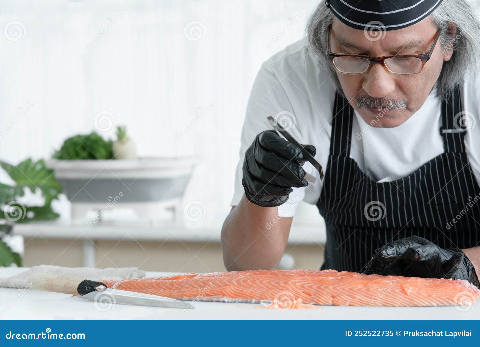 Chef Asiatique Avec Gants Noirs En Utilisant Des Pinces Pour