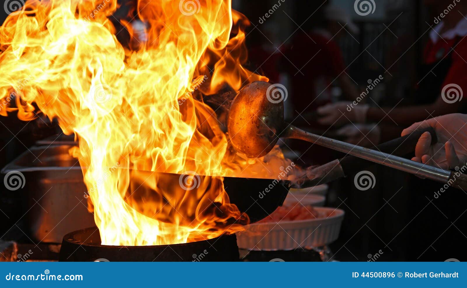 chef cooking with fire in frying pan