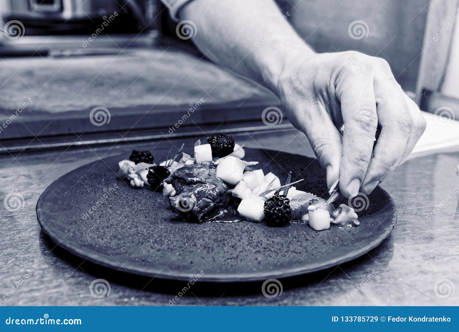 Chef is Decorating Stewed Veal Cheeks with Herbs and Berries, To Stock