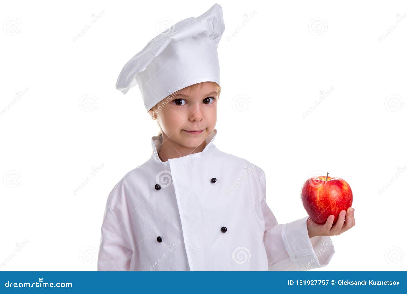 Chef Girl in a Cap Cook Uniform, Holding the Red Apple. Looking at the ...