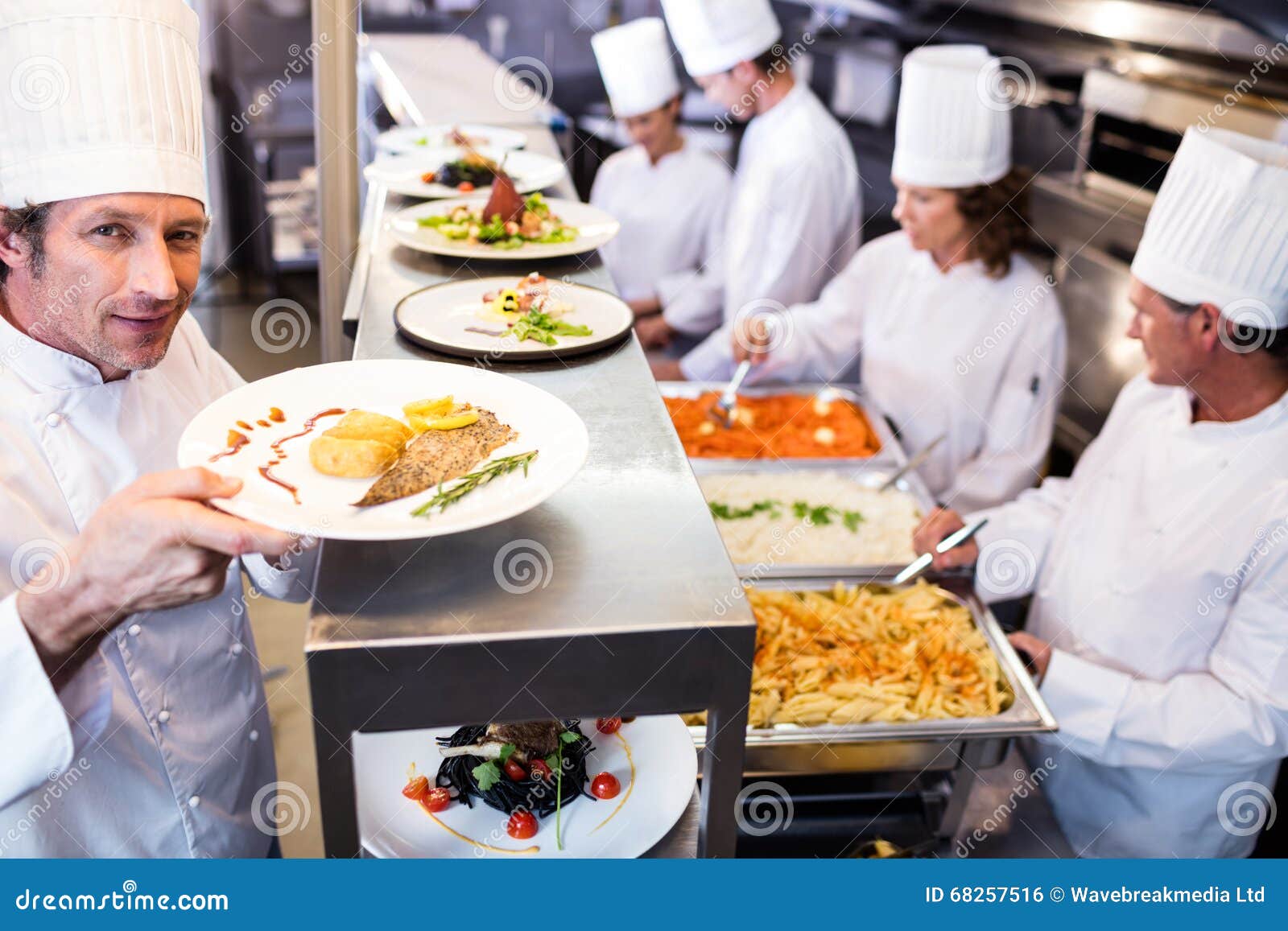 Chef Handing Dinner Plates through Order Station Stock Photo Image of counter, camera 68257516