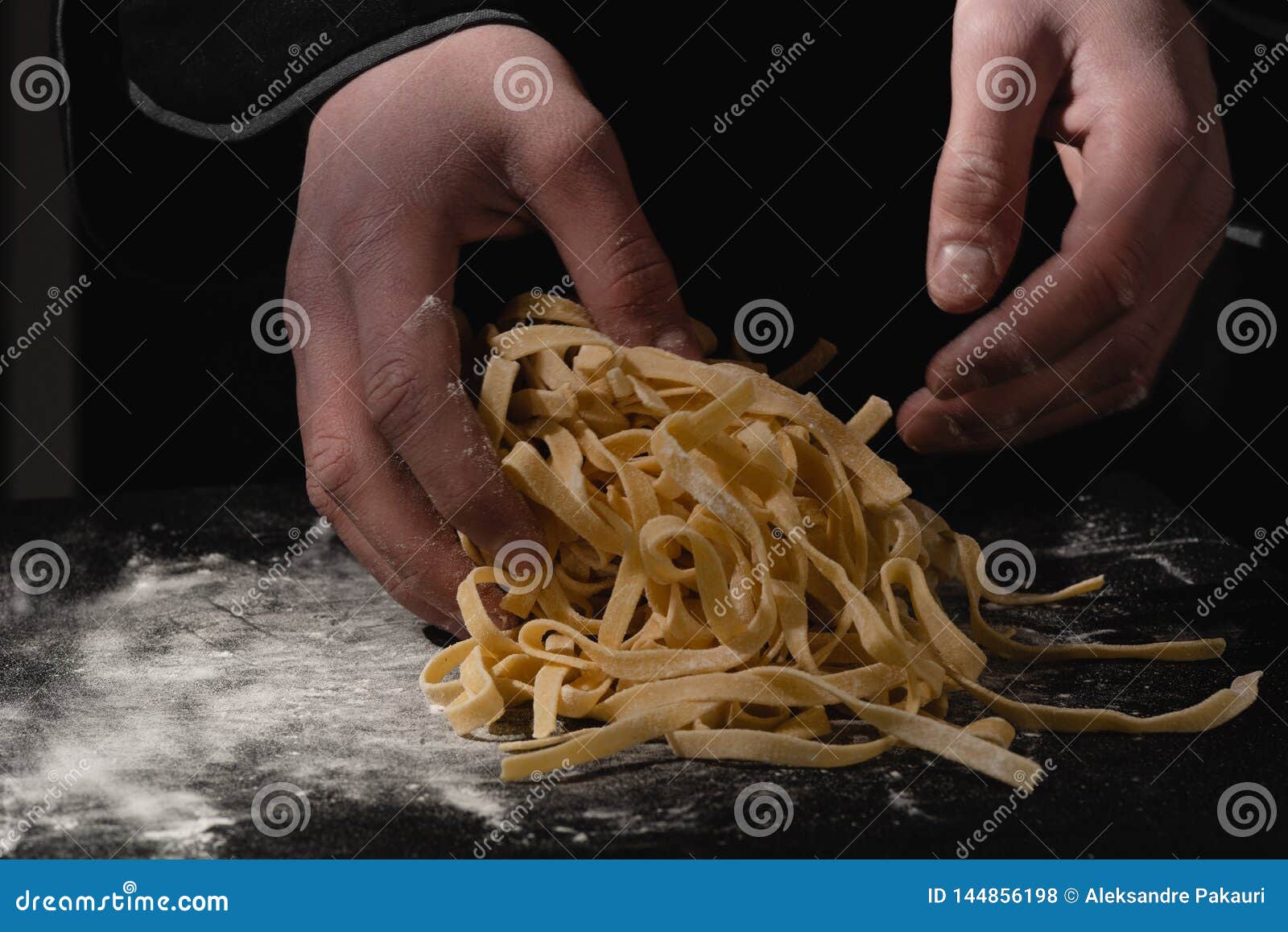 Chef Hands Making Spaghetti, Pasta, Noodles with Fresh Pasta on Black
