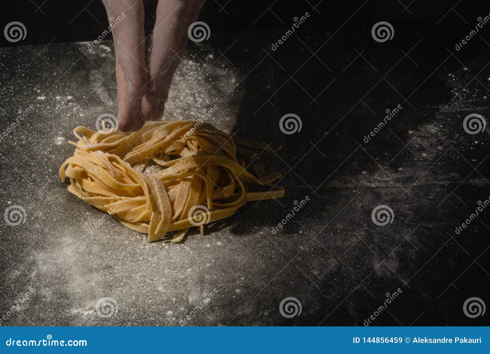 Chef Hands Making Spaghetti, Pasta, Noodles with Fresh Pasta on Black