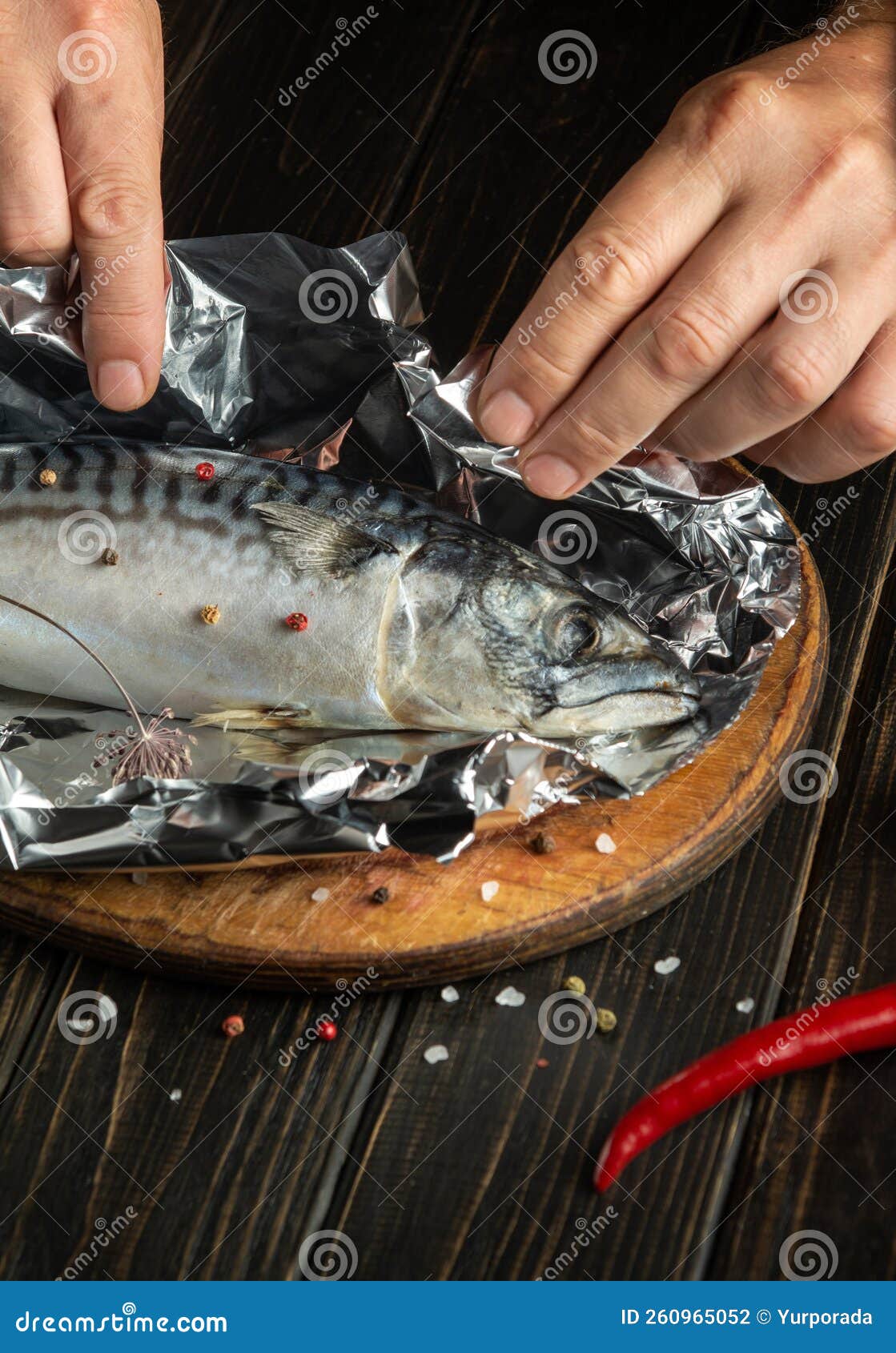 The Chef Hands Preparing Mackerel in the Kitchen. Wrapping Fish in Foil