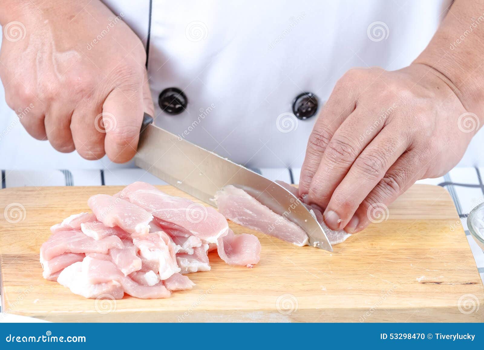 Chef-kok gesneden varkensvlees. Sluit chef-kok omhoog gesneden varkensvlees bij het knipsel bord voor het koken