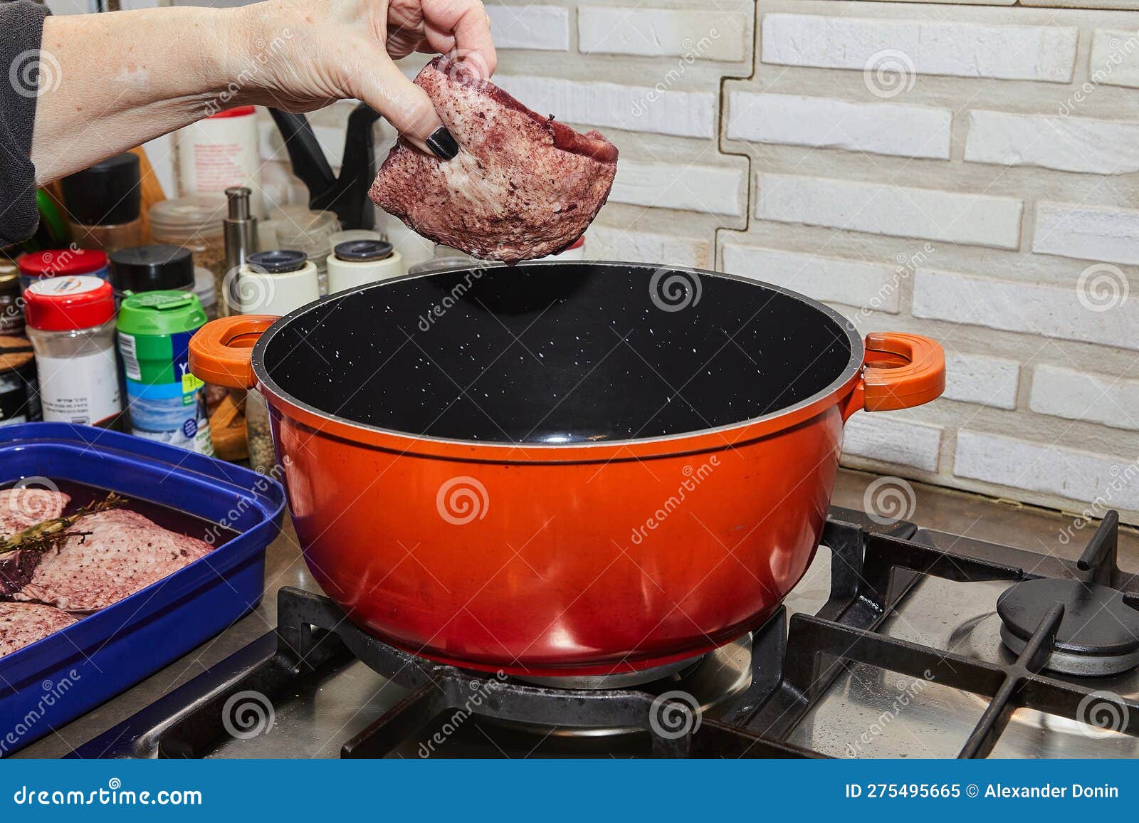 Chef Puts the Chicken, Marinated in Red Wine and Rosemary, into Pot on