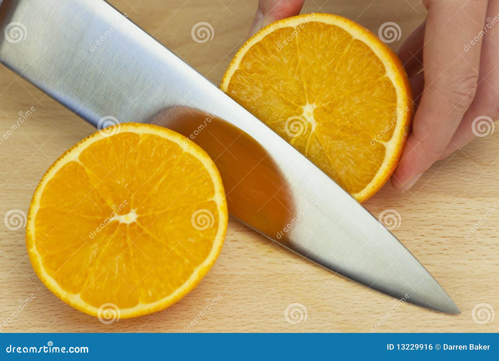 chef slicing fresh orange with sharp kitchen knife