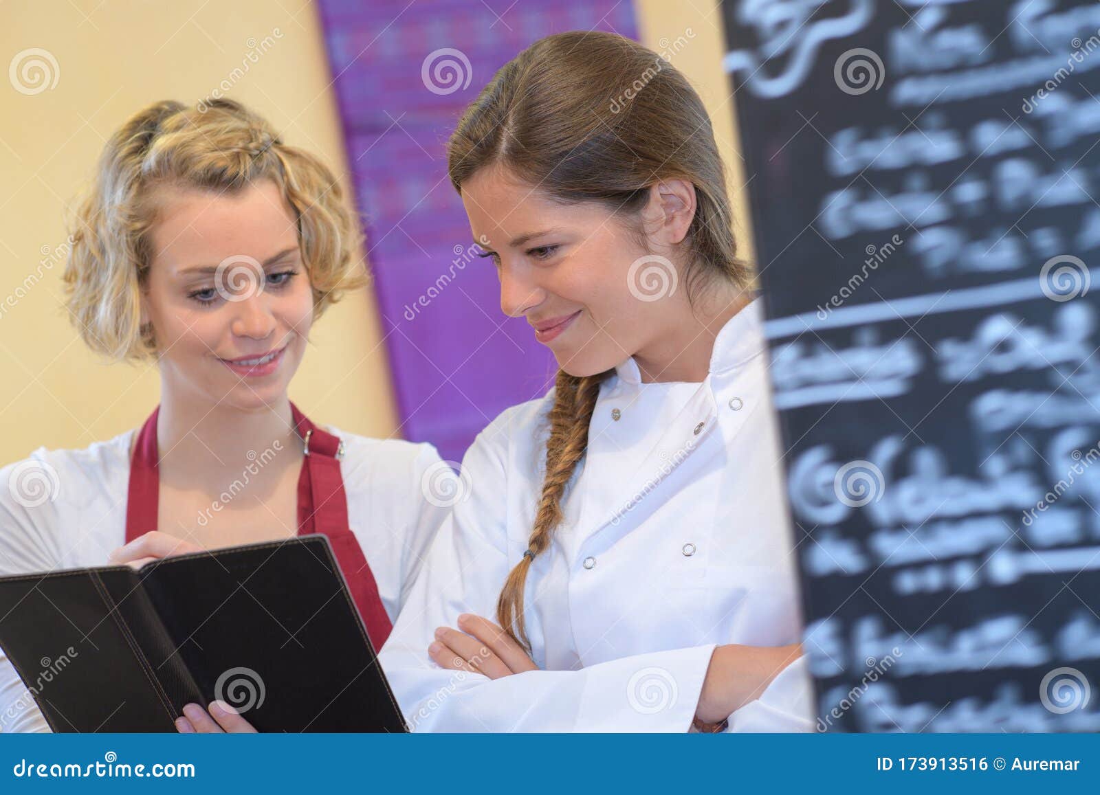 Chef Writing Something in Clipboard in Modern Kitchen Stock Photo