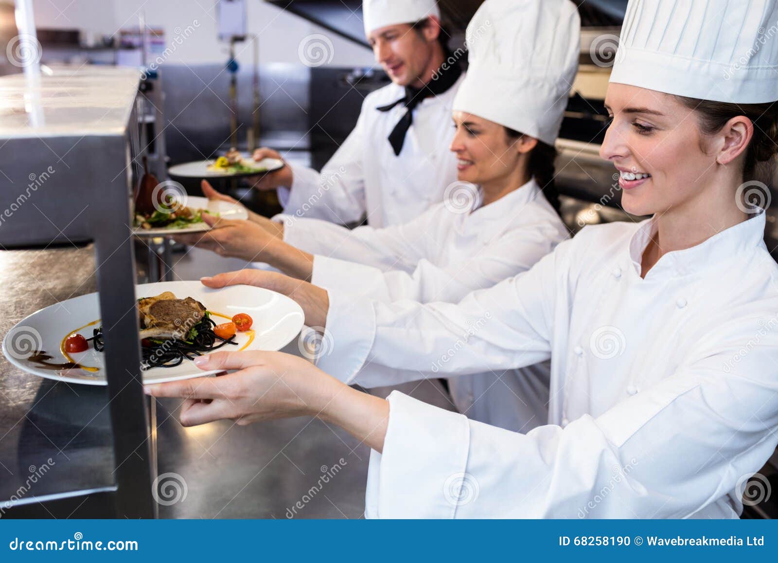 Chefs Handing Dinner Plates through Order Station Stock Photo Image of focus, chefs 68258190