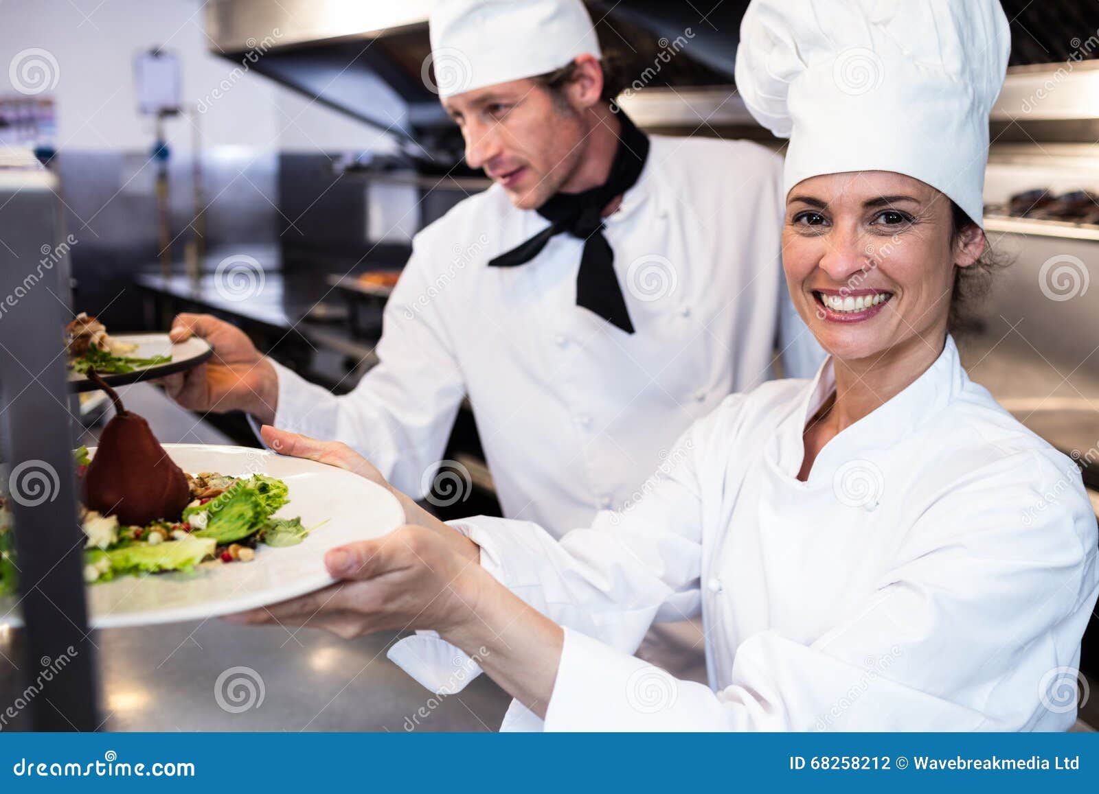 Chefs Handing Dinner Plates through Order Station Stock Photo Image of catering, camera 68258212