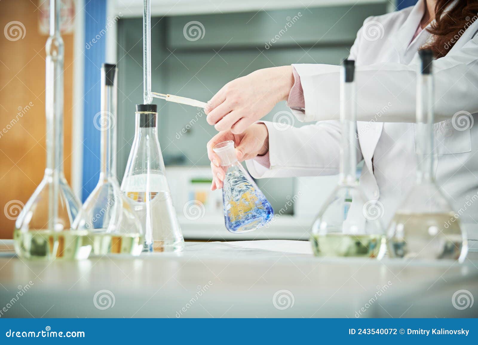 chemical laboratory. hand with flask during titrimetric analysis or titration