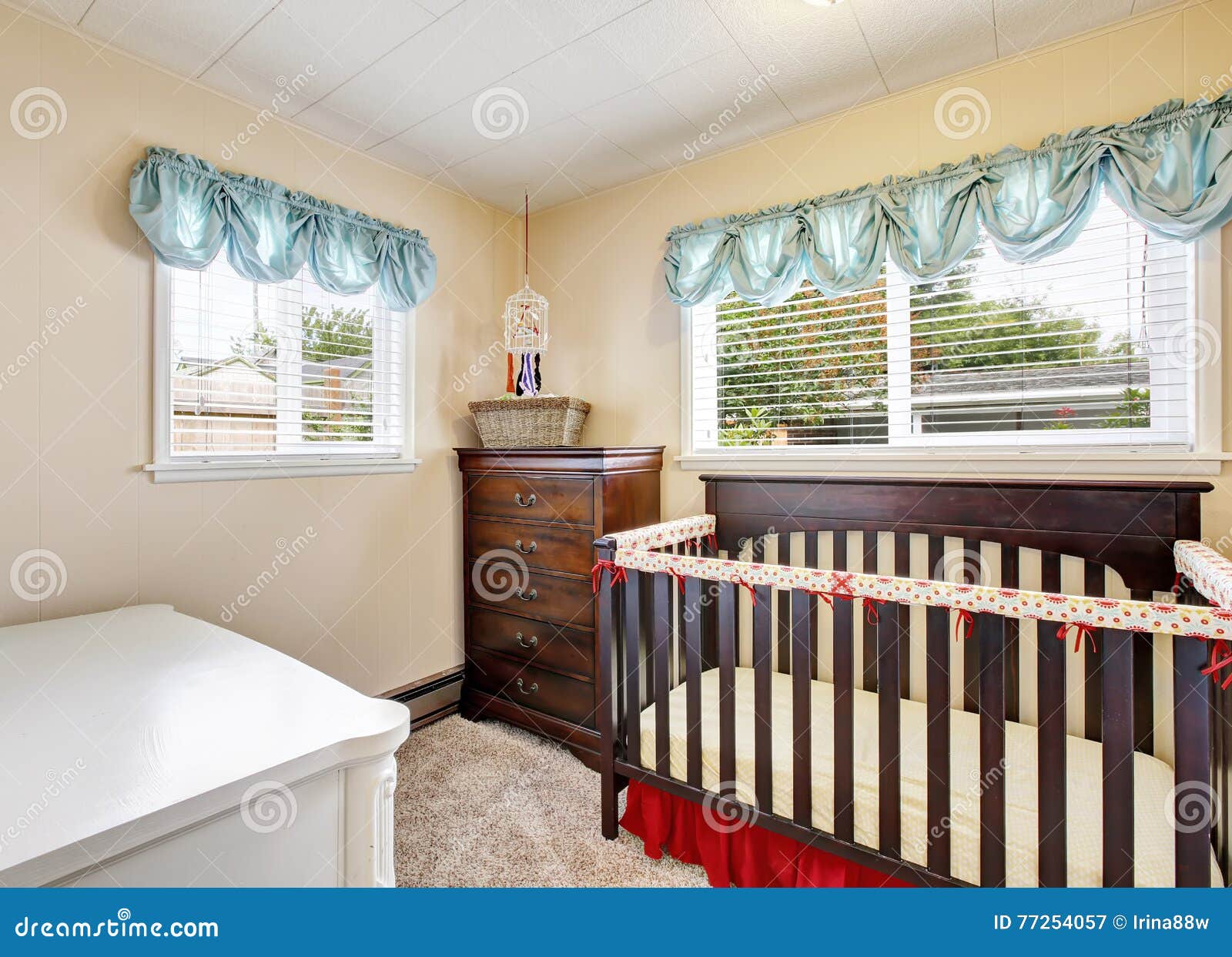 Cherry Wood Baby Crib In Nursery Interior With Carpet Floor Stock