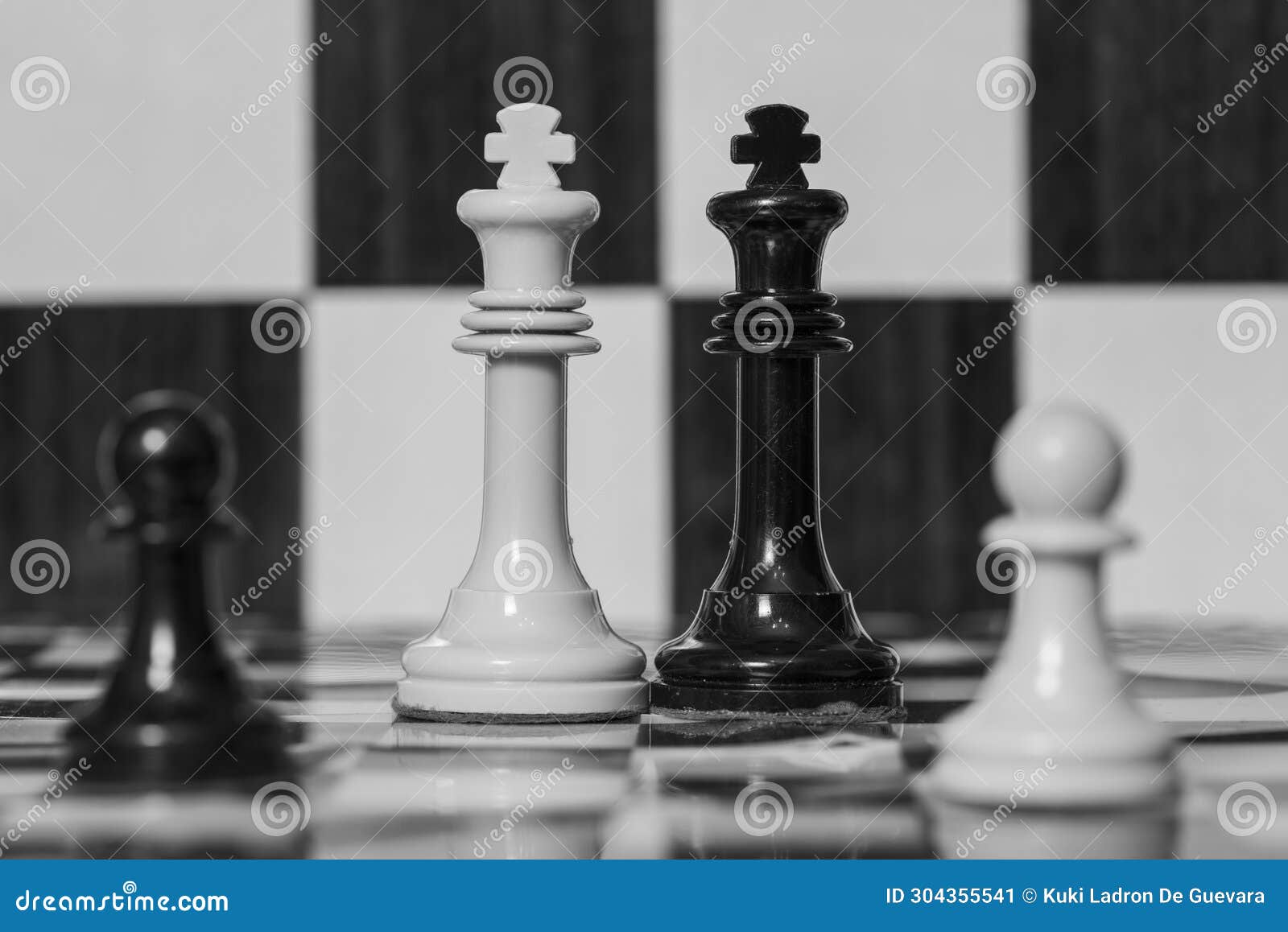 chess pieces, black and white king, on a board